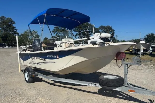 Slide: The Image of 2015 Carolina Skiff 198 DLV boat on trailer with blue canopy in outdoor setting. - 2