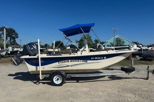Slide: The Image of 2015 Carolina Skiff 198 DLV boat with blue canopy on trailer, labeled "Fishin Addiction." - 3