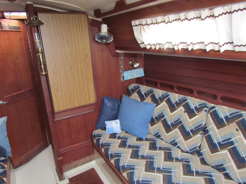 Slide: The Image of Cozy interior of 1982 Ericson 25 sailboat with patterned cushions and wood paneling. - 10