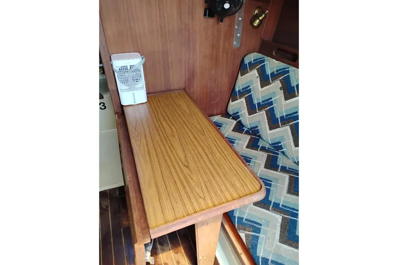 Slide: The Image of Interior of 1982 Ericson 25 sailboat with wooden table and patterned seating. - 16