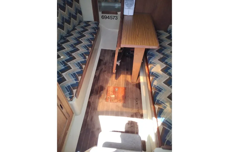 Slide: The Image of Interior of 1982 Ericson 25 sailboat with patterned seating and wooden table. - 17