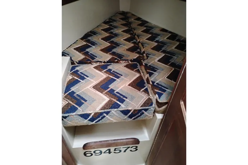 Slide: The Image of Interior of 1982 Ericson 25 sailboat with patterned cushions and visible hull number. - 19
