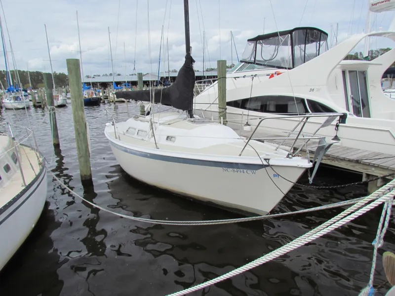 Slide: The Image of 1982 Ericson 25 sailboat docked at a marina, surrounded by other boats. - 4