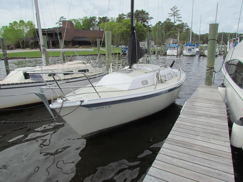 Slide: The Image of 1982 Ericson 25 sailboat docked at a marina with surrounding boats. - 5