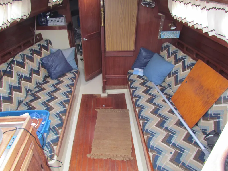 Slide: The Image of Cozy 1982 Ericson 25 sailboat interior with patterned cushions and wooden accents. - 7