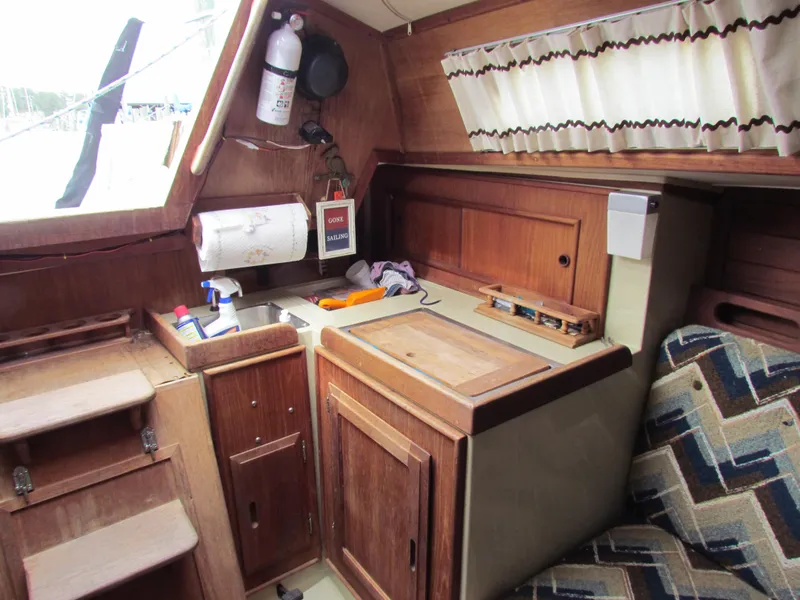 Slide: The Image of Interior of 1982 Ericson 25 sailboat with wooden cabinetry and compact kitchen area. - 9
