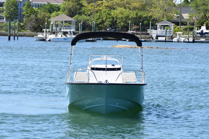 Slide: The Image of 2022 Boston Whaler 190 Montauk boat on calm water near a marina. - 4