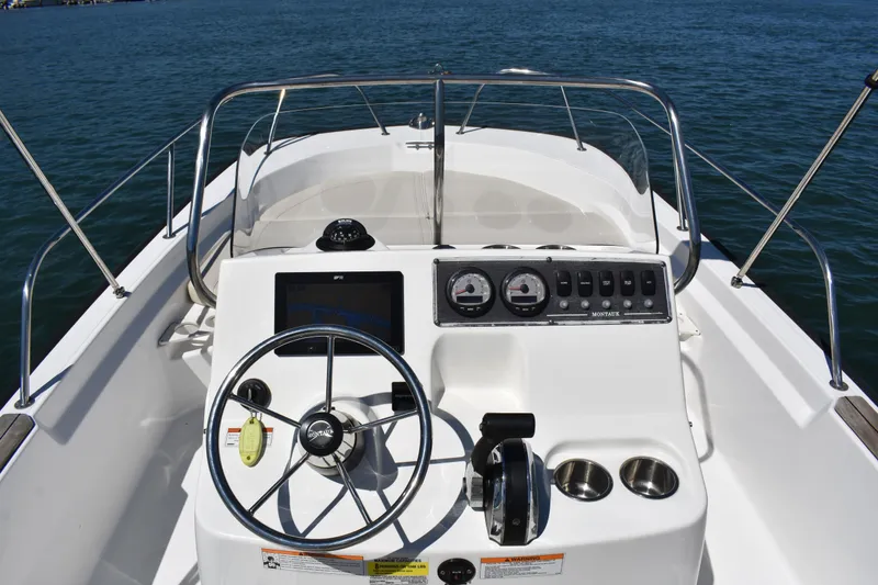 Slide: The Image of 2022 Boston Whaler 190 Montauk boat dashboard with steering wheel and controls. - 9