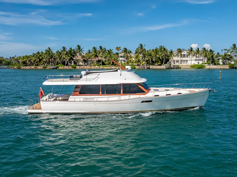 The Image of 2018 Grand Banks GB60 yacht cruising on blue water near a tropical shoreline. - 0