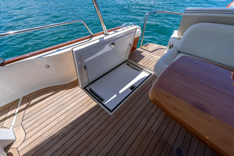 Slide: The Image of 2018 Grand Banks GB60 yacht deck with open storage compartment and elegant wood finish. - 15