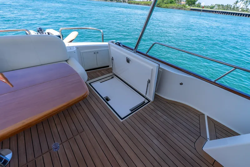 Slide: The Image of 2018 Grand Banks GB60 yacht deck with open hatch, wooden flooring, and ocean view. - 16