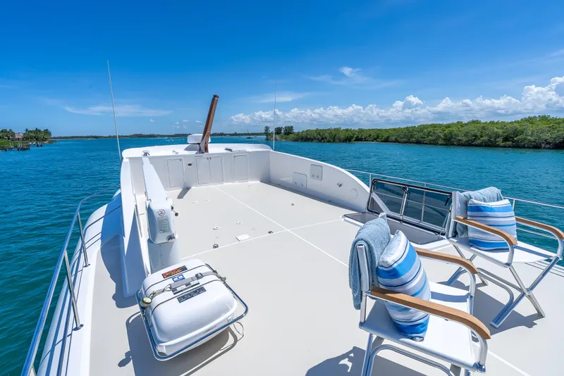 Slide: The Image of 2018 Grand Banks GB60 yacht deck with chairs, cushions, and scenic water view. - 18