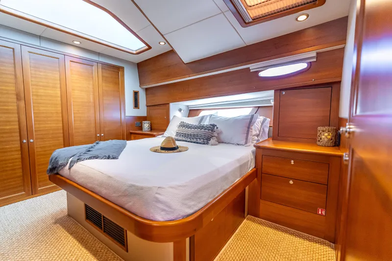 Slide: The Image of Luxurious 2018 Grand Banks GB60 yacht bedroom with elegant wood finishes and cozy bedding. - 4