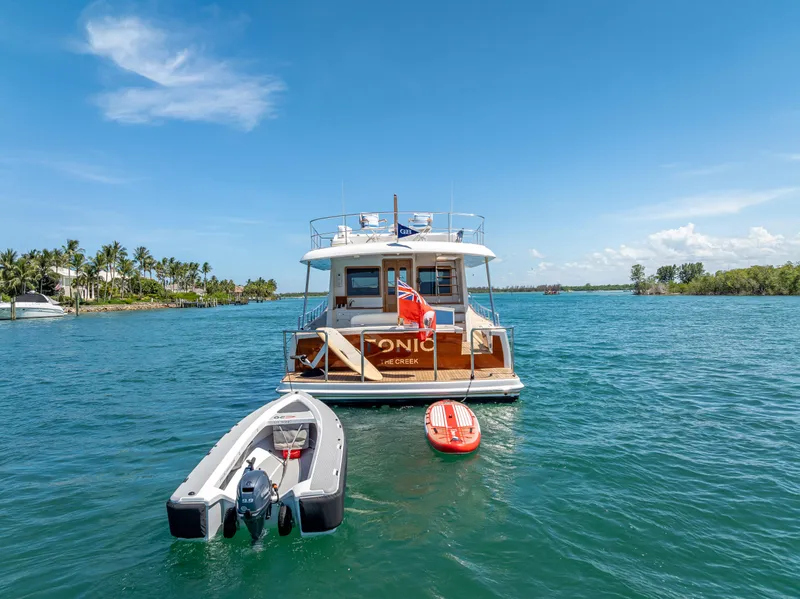 Slide: The Image of 2018 Grand Banks GB60 yacht on water with dinghy and paddleboard. - 6