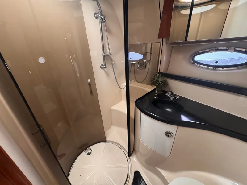 Slide: The Image of The image shows a sleek boat bathroom with a shower, sink, and mirror. - 24