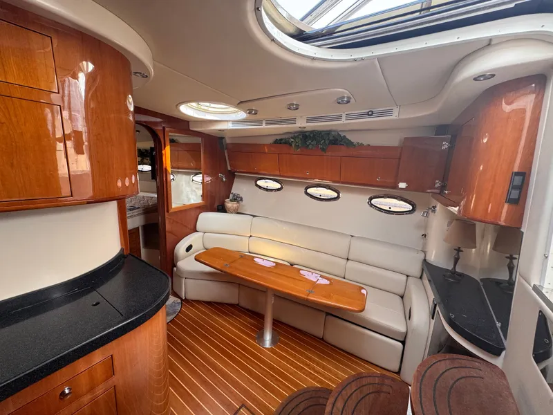 Slide: The Image of Interior of a 2006 Regal Commodore 3860 with elegant wood furnishings and cream-colored upholstery. - 16