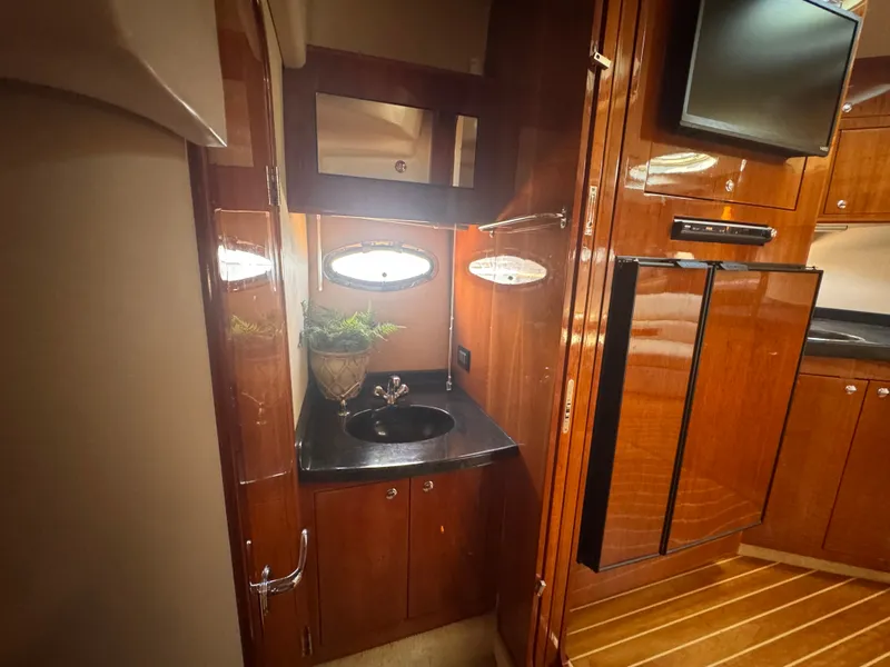 Slide: The Image of The interior of a 2006 Regal Commodore 3860 features elegant wood paneling and a sink. - 28