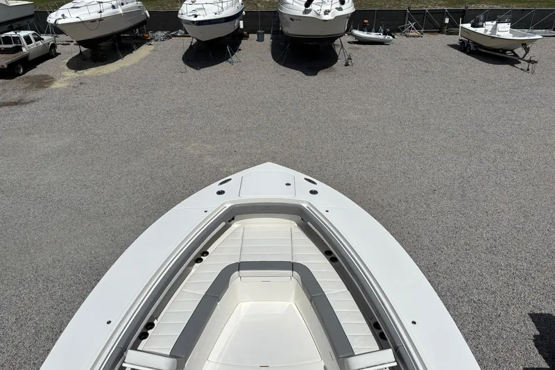 Slide: The Image of Bow view of 2023 Regulator 41 boat in a gravel lot with other boats. - 13