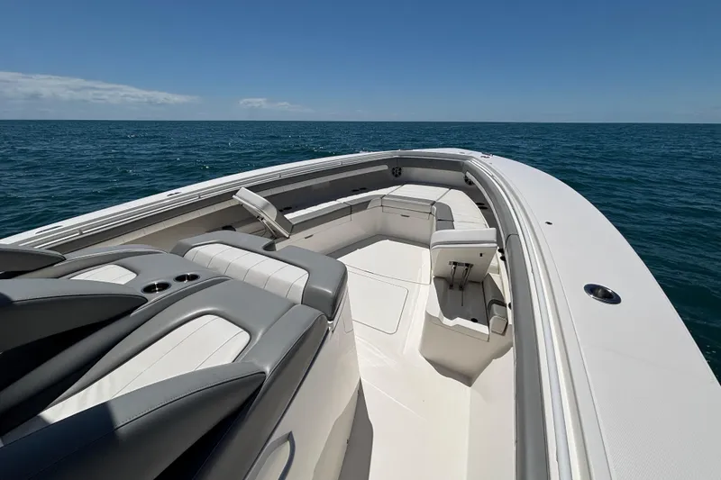 Slide: The Image of 2023 Regulator 41 boat with spacious seating, cruising on open ocean under clear blue sky. - 14
