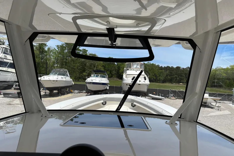 Slide: The Image of Interior view of a 2023 Regulator 41 boat, showcasing the windshield and docked boats. - 30