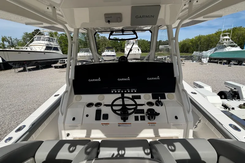 Slide: The Image of 2023 Regulator 41 boat cockpit with Garmin navigation system, docked among other boats. - 36