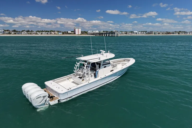 Slide: The Image of 2023 Regulator 41 boat on calm ocean near coastal town, clear sky. - 4