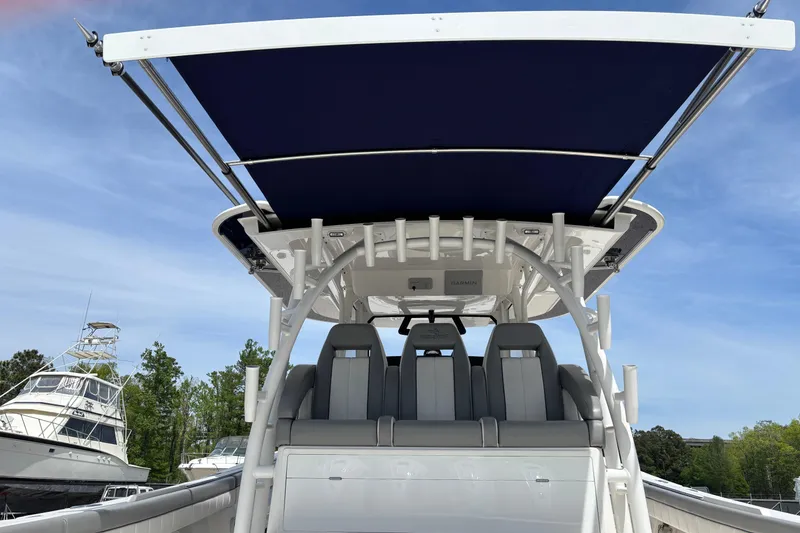 Slide: The Image of 2023 Regulator 41 boat with sleek seating and canopy, docked under clear skies. - 44