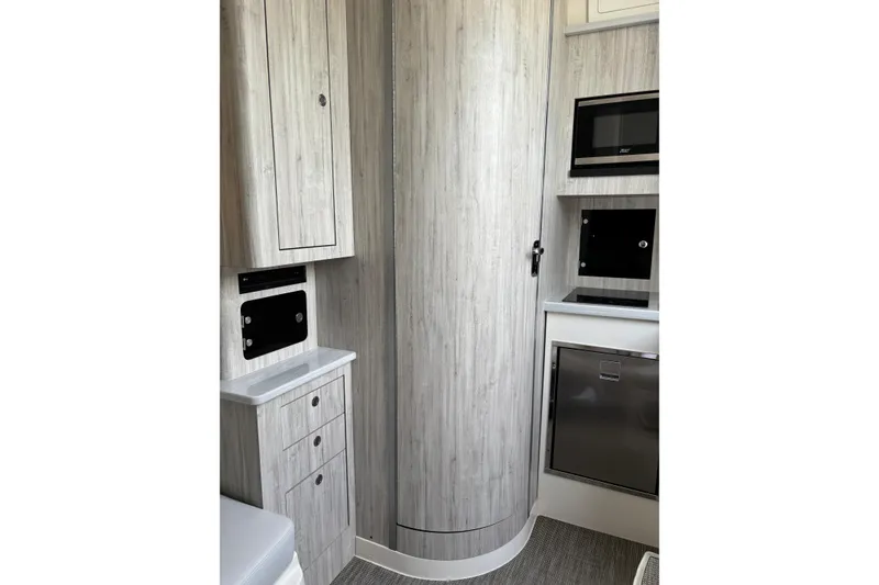 Slide: The Image of 2023 Regulator 41 interior with modern cabinetry, microwave, and compact fridge. - 57