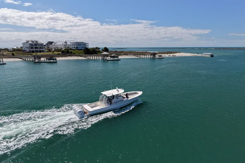 Slide: The Image of 2023 Regulator 41 boat cruising near coastal homes and docks. - 6