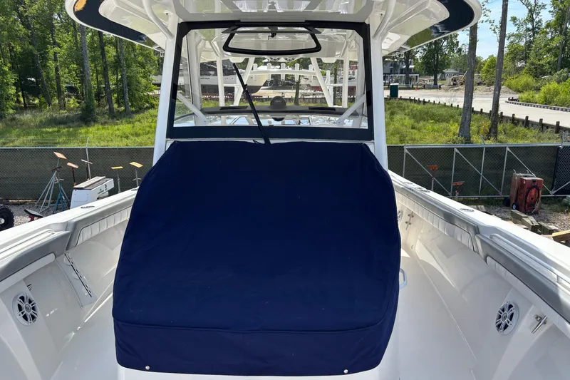 Slide: The Image of 2023 Regulator 41 boat with blue cover, docked outdoors. - 63