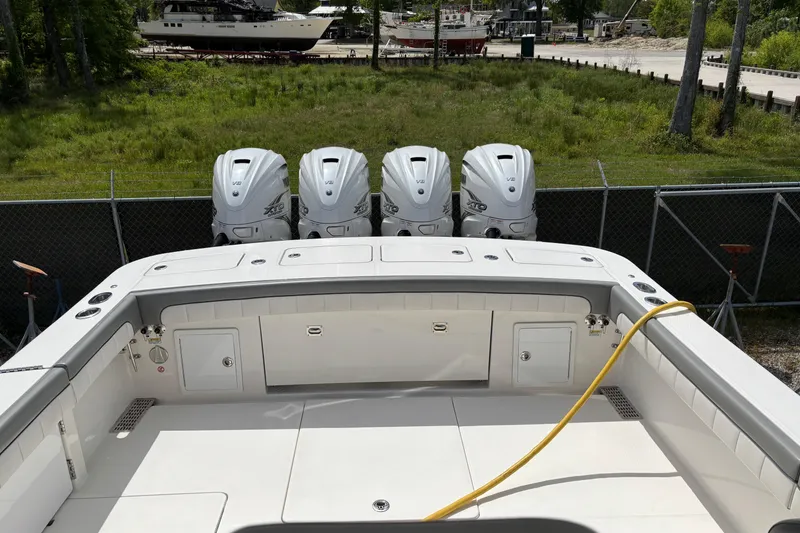 Slide: The Image of 2023 Regulator 41 boat with four powerful outboard engines, docked in a grassy area. - 69