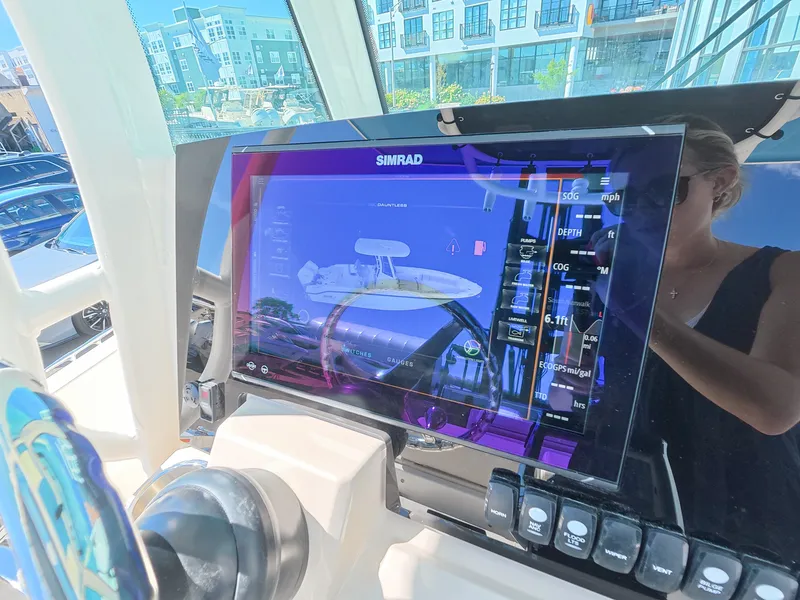 Slide: The Image of The image shows a modern Simrad navigation system on a boat, surrounded by control elements. - 14