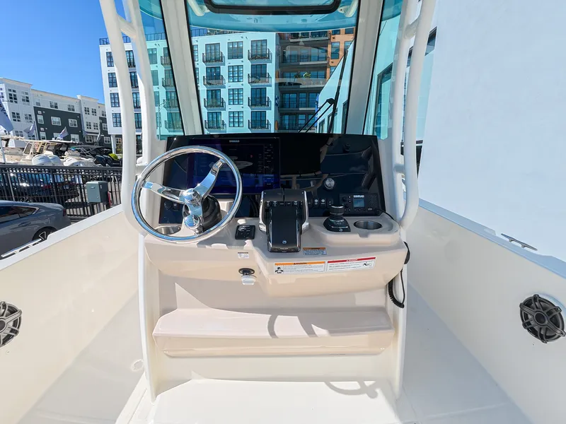 Slide: The Image of The cockpit of the 2027 Boston Whaler 280 Dauntless features a modern helm with a steering wheel. - 13