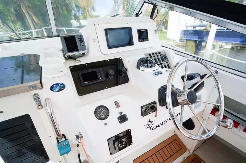 Slide: The Image of 1995 Grady-White Marlin 300 boat cockpit with steering wheel and navigation instruments. - 12
