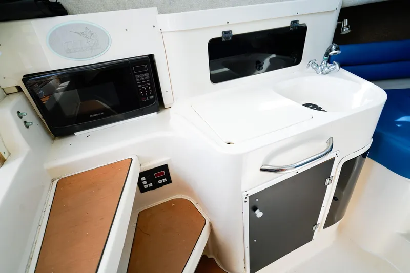 Slide: The Image of 1995 Grady-White Marlin 300 boat interior with microwave, sink, and storage. - 15