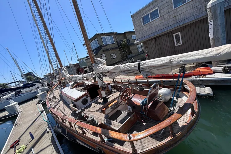 Slide: The Image of Vintage 1970 Chen sailboat docked at a marina, showcasing wooden deck and rigging. - 3
