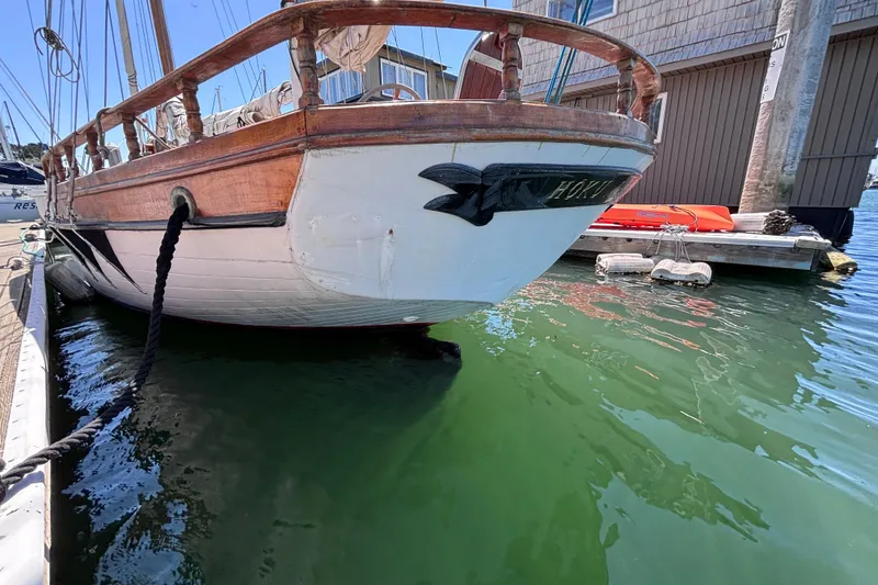 Slide: The Image of Vintage Chen sailboat from 1970 docked in a marina, featuring wooden railings. - 4