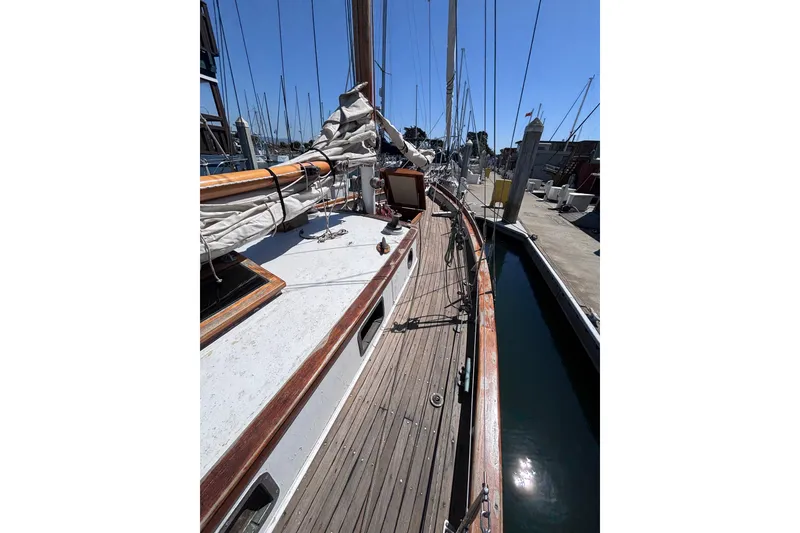 Slide: The Image of Vintage 1970 Chen sailboat docked at marina, showcasing wooden deck and rigging. - 5