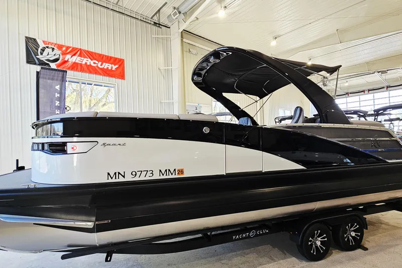 The Image of 2024 Bennington RX 23 RXFBA pontoon boat displayed indoors with Mercury banner. - 1