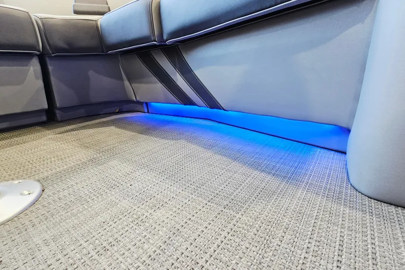 Slide: The Image of 2024 Bennington RX 23 RXFBA interior with blue LED lighting and gray seating. - 18