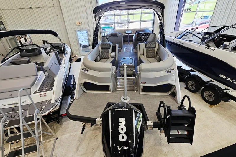 Slide: The Image of 2024 Bennington RX 23 RXFBA pontoon boat displayed indoors with Mercury 300 V8 engine. - 3