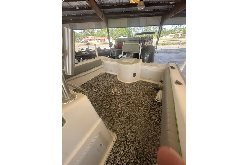 Slide: The Image of 2002 Cape Horn 27 XS boat interior with textured flooring and seating under a shelter. - 9