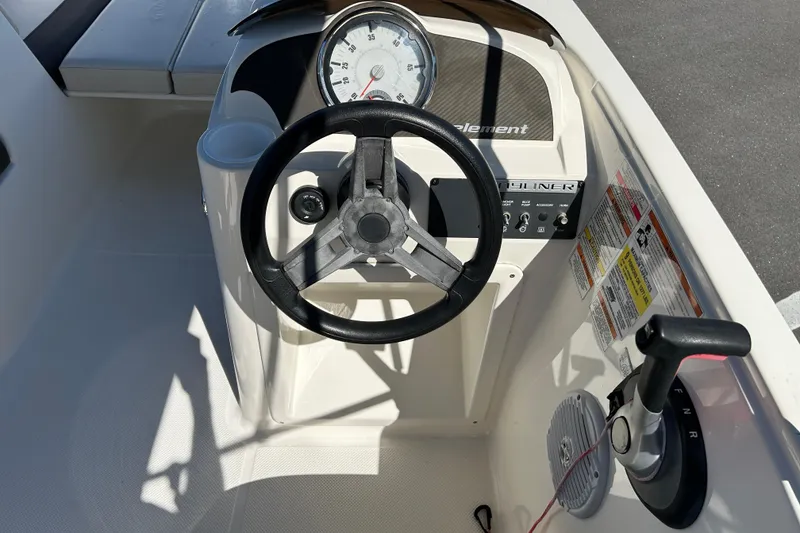 Slide: The Image of 2019 Bayliner Element E18 boat dashboard with steering wheel and control panel. - 10