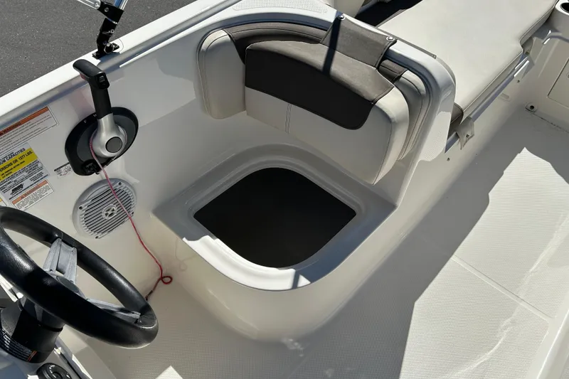 Slide: The Image of 2019 Bayliner Element E18 boat interior with steering wheel and seating area. - 15