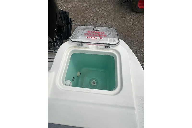 Slide: The Image of 2023 NAUTIC STAR 22 L boat livewell with open lid, showcasing interior. - 11