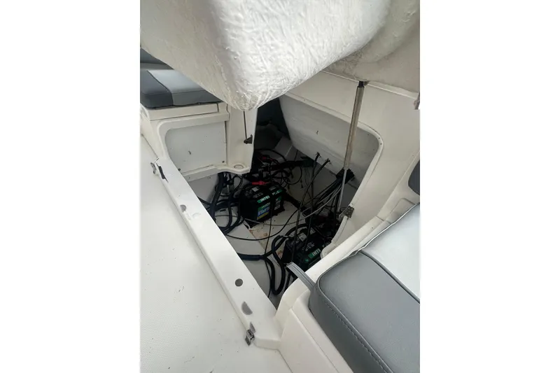 Slide: The Image of 2023 NAUTIC STAR 22 L boat interior showing battery compartment and wiring. - 12