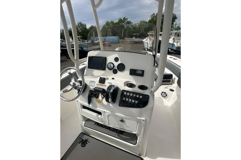 Slide: The Image of 2023 NAUTIC STAR 22 L boat dashboard with steering wheel and control panel. - 16