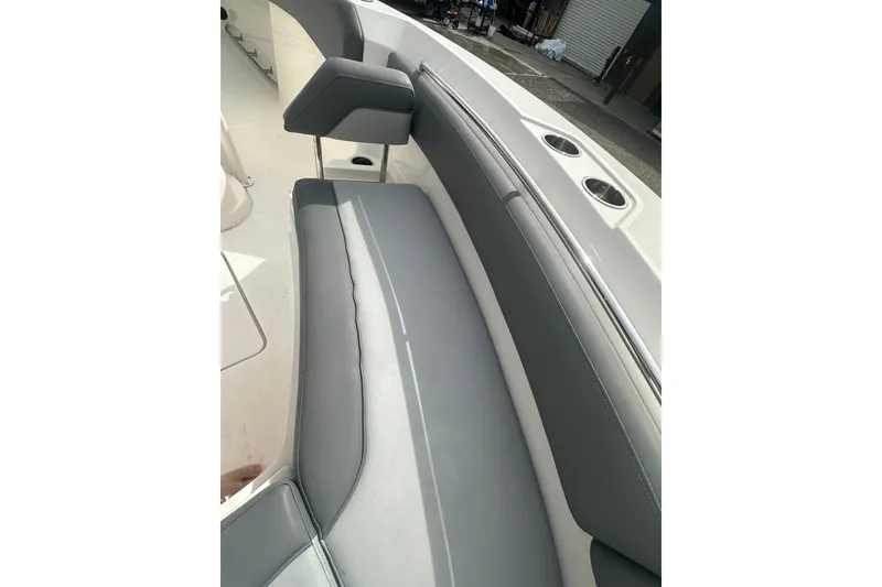 Slide: The Image of 2023 NAUTIC STAR 22 L boat interior with gray seating and cup holders. - 23