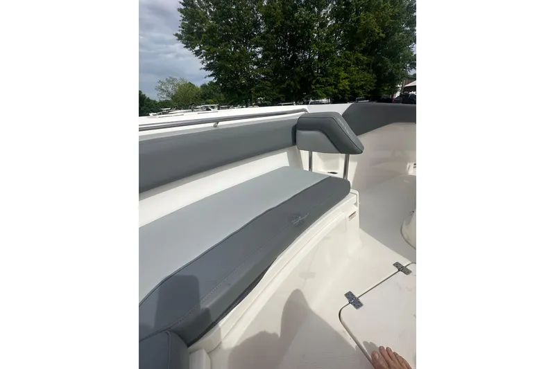 Slide: The Image of 2023 NAUTIC STAR 22 L boat interior with gray seating and lush greenery background. - 24