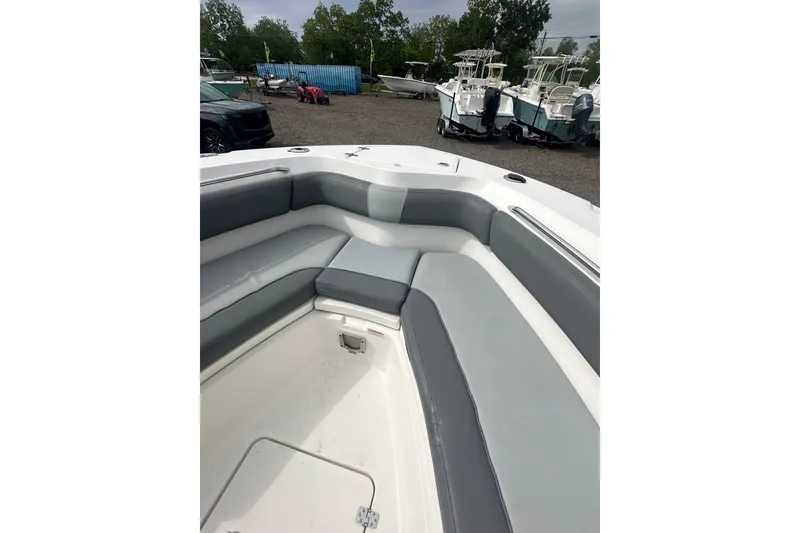 Slide: The Image of 2023 NAUTIC STAR 22 L boat interior with gray seating and storage compartment. - 26